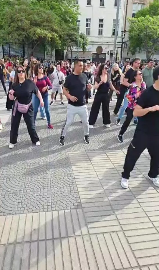 Grupo grande bailando bachata en una plaza, al aire libre